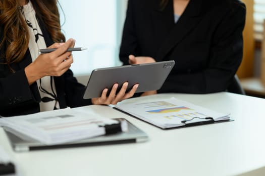 Cropped shot of businesswoman discussing work issues and using digital tablet at office table.