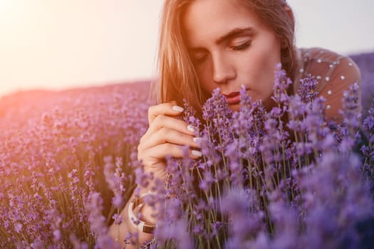 Close up portrait of young beautiful woman in a white dress and a hat is walking in the lavender field and smelling lavender bouquet.