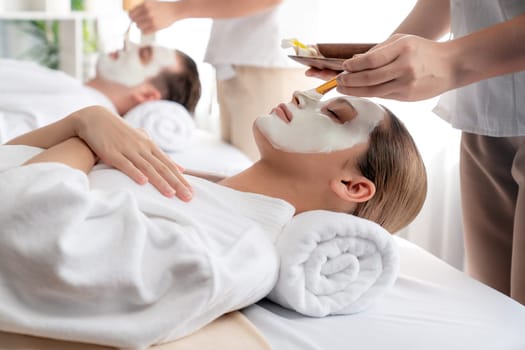 Serene ambiance of spa salon, couple indulges in rejuvenating with luxurious face cream massage with modern daylight. Facial skin treatment and beauty care concept. Quiescent