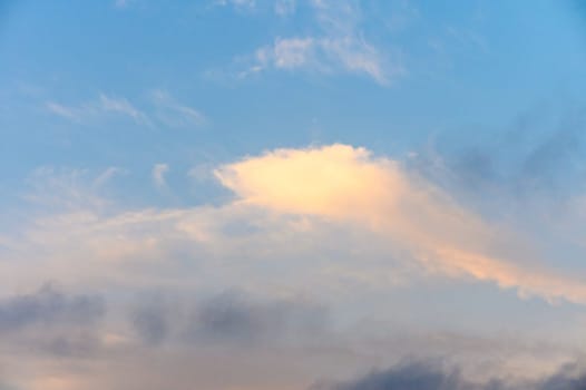 Light pink clouds in sunset blue sky.