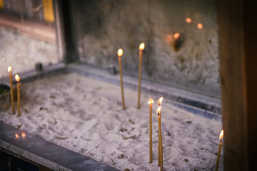 burning candles on sand, lit for loved ones