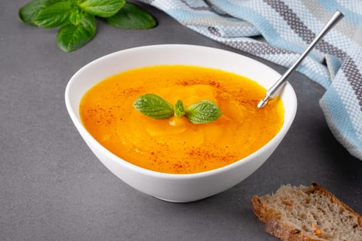 Pumpkin soup on grey background, with copy space for text.