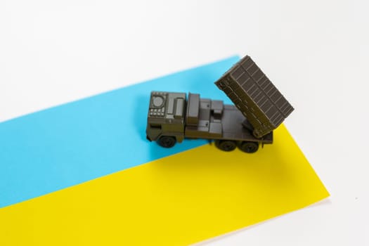 Artillery rocket system are aimed to the sky and soldier at sunset with Ukrainian flag. Multiple launch rocket system. High quality photo
