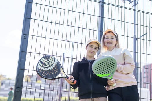 mother and daughter playing padel outdoor. High quality photo