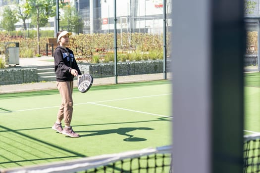 Ukraine Kyiv, April 20 2024. happy pretty girl practicing paddle sport on the paddle court. High quality photo