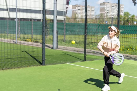Ukraine Kyiv, April 20 2024. Portrait of smiling woman paddle tennis player during couple match at court. High quality photo