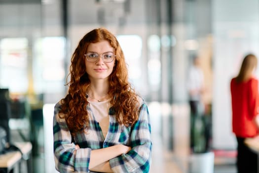 A portrait of a young businesswoman with modern orange hair captures her poised presence in a hallway of a contemporary startup coworking center, embodying individuality and professional confidence