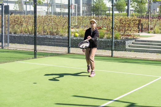 little girl playing padel and hitting the ball with his racket outdoors sports concepts. High quality photo