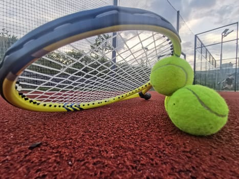 yellow tennis balls and two racquet on hard tennis court surface, top view tennis scene. High quality photo