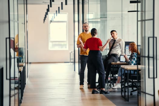 A dynamic group of young entrepreneurs engages in vibrant discussion within a modern glass office space, exploring new business projects and fostering innovation.