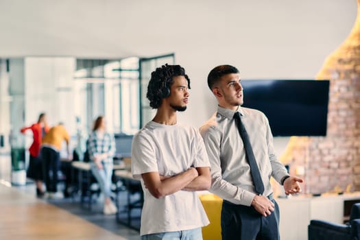 A group of colleagues, including an African American businessman and a young leader in a shirt and tie, pose together in a modern coworking center office, representing a dynamic blend of professionalism and collaboration.