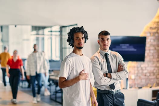 A group of colleagues, including an African American businessman and a young leader in a shirt and tie, pose together in a modern coworking center office, representing a dynamic blend of professionalism and collaboration.