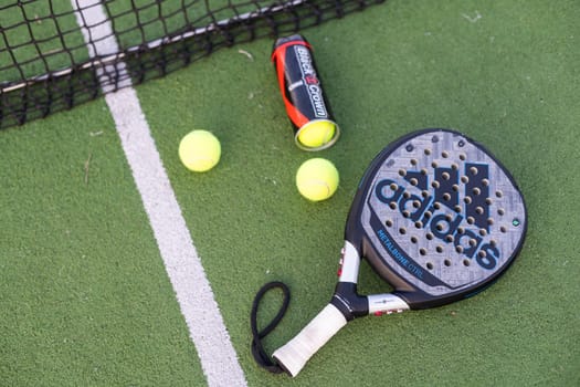 Ukraine Kyiv, 30.03.2024: Padel racket adidas and padel ball on a green court. High quality photo
