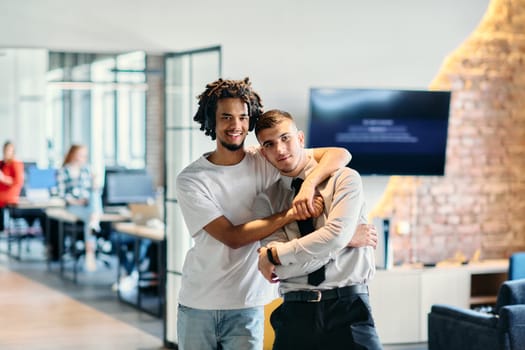 A group of colleagues, including an African American businessman and a young leader in a shirt and tie, pose together in a modern coworking center office, representing a dynamic blend of professionalism and collaboration.