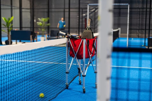Paddle tennis rackets, balls and basket in court still life. High quality photo