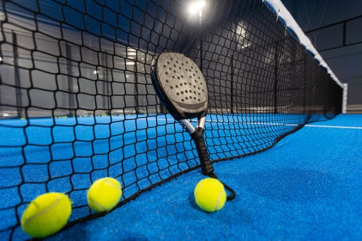 paddle tennis racket and balls on the blue paddle court. High quality photo