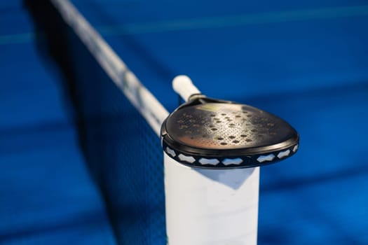 Paddle tennis: Paddel racket and ball in front of an outdoor court. High quality photo