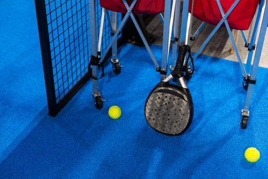 balls near the net of a blue padel tennis court. High quality photo