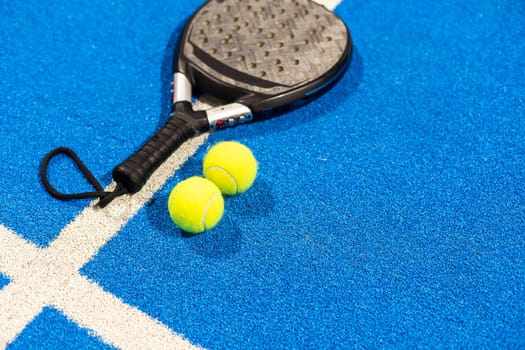 paddle tennis racket and balls on the blue paddle court. High quality photo