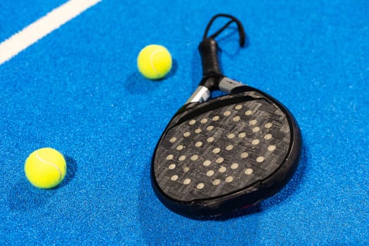 paddle tennis racket and balls on the blue paddle court. High quality photo