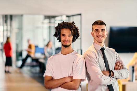 A group of colleagues, including an African American businessman and a young leader in a shirt and tie, pose together in a modern coworking center office, representing a dynamic blend of professionalism and collaboration.