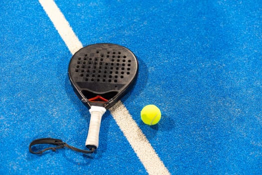 paddle tennis racket and balls on the blue paddle court. High quality photo