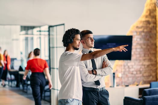 A group of colleagues, including an African American businessman and a young leader in a shirt and tie, pose together in a modern coworking center office, representing a dynamic blend of professionalism and collaboration.