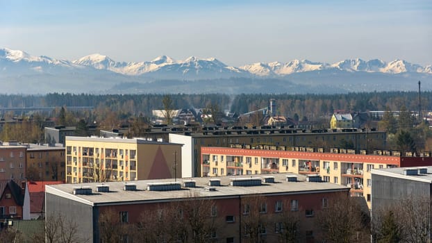 Panoramic view of the rooftops of Nowy Targ with snow capped Tatra mountains in the background