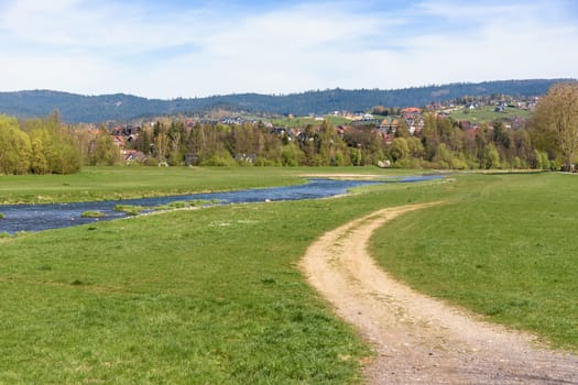 View of Bialy Dunajec river with residential buildings on the hill in the city of Nowy Targ, Poland