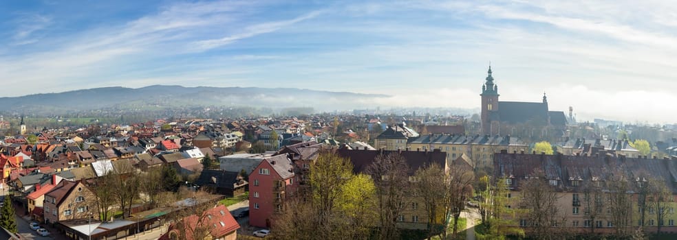 Panoramic view of the rooftops of Nowy Targ with the morning fog in the background