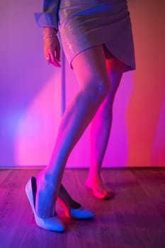 Woman legs closeup in stokings with neon color background