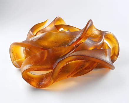 A close up of an amber cuisine ingredient, resembling a peach color, on a white surface. The object could be a fashion accessory, jewelry, or art made of metal or glass in an electric blue hue