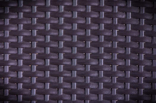 dark brown plastic weave texture pattern. This is a popular pattern for rattan mats, baskets or furniture.