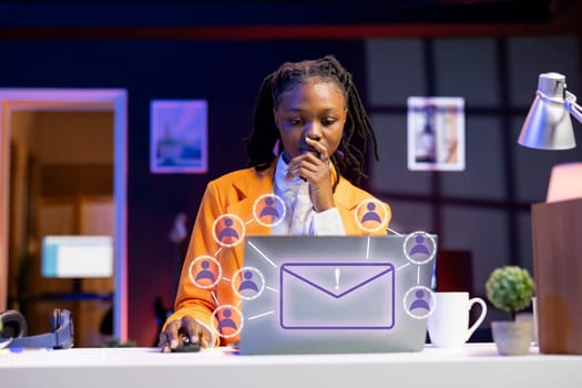 African american woman working on laptop, sending emails to business partners, online connectivity concept. Remote worker using XR augmented reality tech to interact with notebook screen