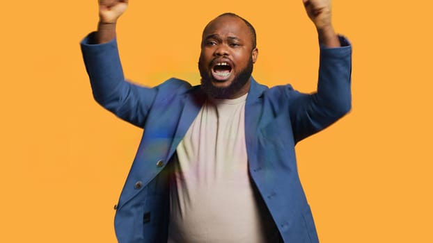Approving joyful african american man happily clapping hands, ecstatic about accomplishments. Excited BIPOC person cheering, applauding, isolated over studio background, camera A