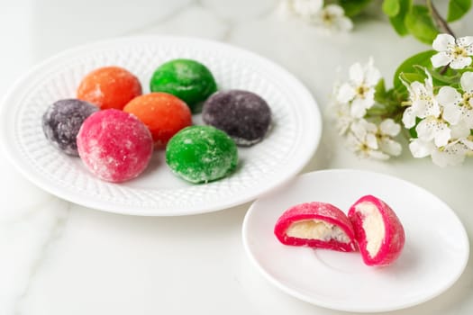 Multi-colored Japanese cakes Mochi in a white plate close up