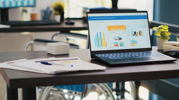 Business figures on laptop monitors left open in company workspace, panning shot. Notebook with economic charts in empty accounting department office used for financial analysis purposes