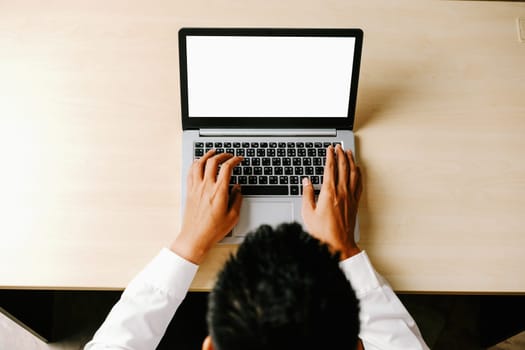 Business person or office worker using laptop computer while sitting at desk. uds