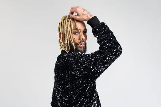 Man wearing stylish jacket with sequins on naked body. Afro-american homosexual male posing in photo studio on white background. Bearded gay with beard and make up close up portrait