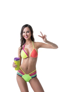 Charming sporty woman in bright bikini posing with shaker