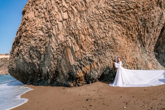 Woman beach white dress flying on Wind. Summer Vacation. A happy woman takes vacation photos to send to friends