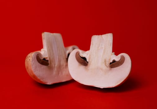 two mushrooms of mushrooms in a cut on a red background.