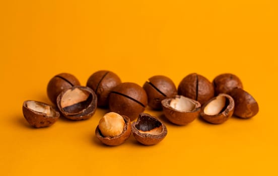 split macadamia nut close-up on an orange background.