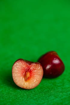 cherry with a stone in a section on a green background.