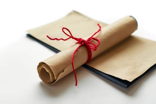 Roll of paper with red string tied around it. Generative AI.