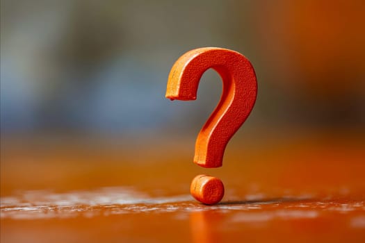 A question mark is made out of a small orange object. The orange object is placed on a table or a surface. Concept of curiosity and intrigue, as the question mark is a symbol of asking questions. Generative AI
