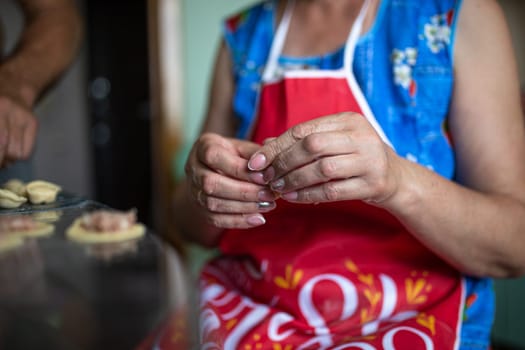 homemade cooking of dumplings with women's hands in the kitchen