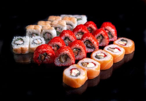 bright sushi set on black background for menu design.