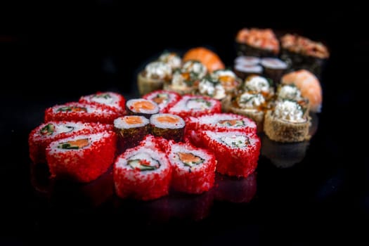 rolls with red caviar close-up on a black background. Japanese cuisine.