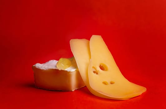 hard and soft cheese with white mold on a red background.